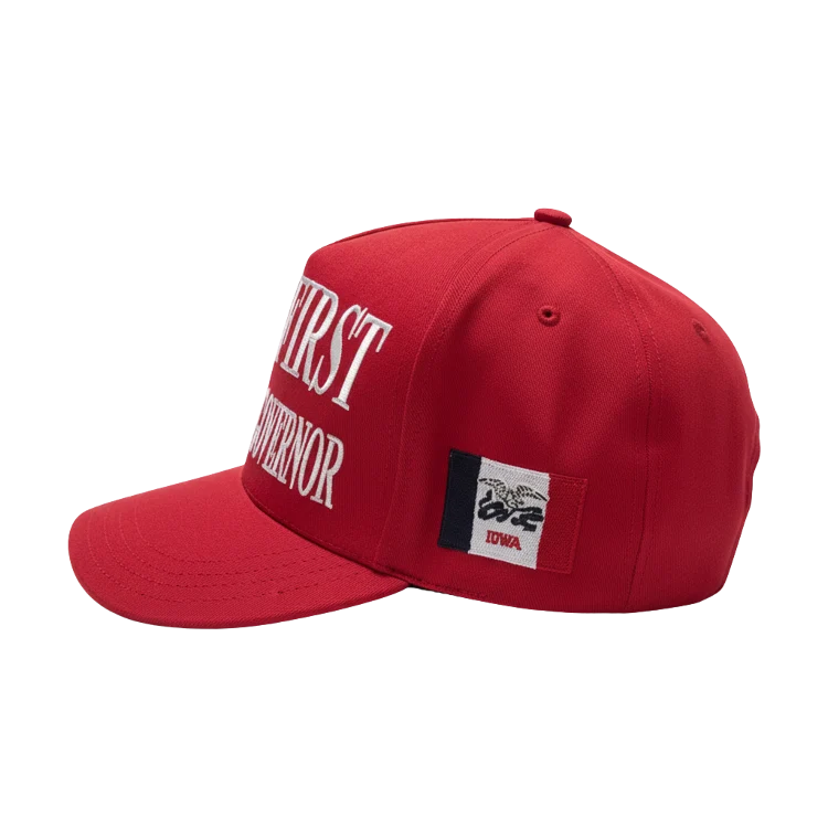 Red baseball cap displaying "Iowa First" and the Iowa state flag, representing Zach Lahn's campaign