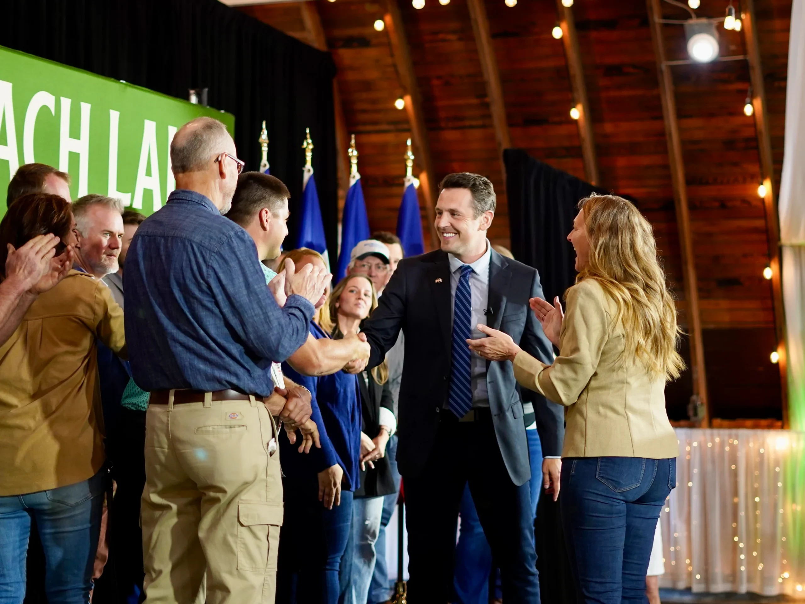 Zach Lahn, a sixth-generation Iowan farmer and businessman, shakes hands with supporters at a campaign